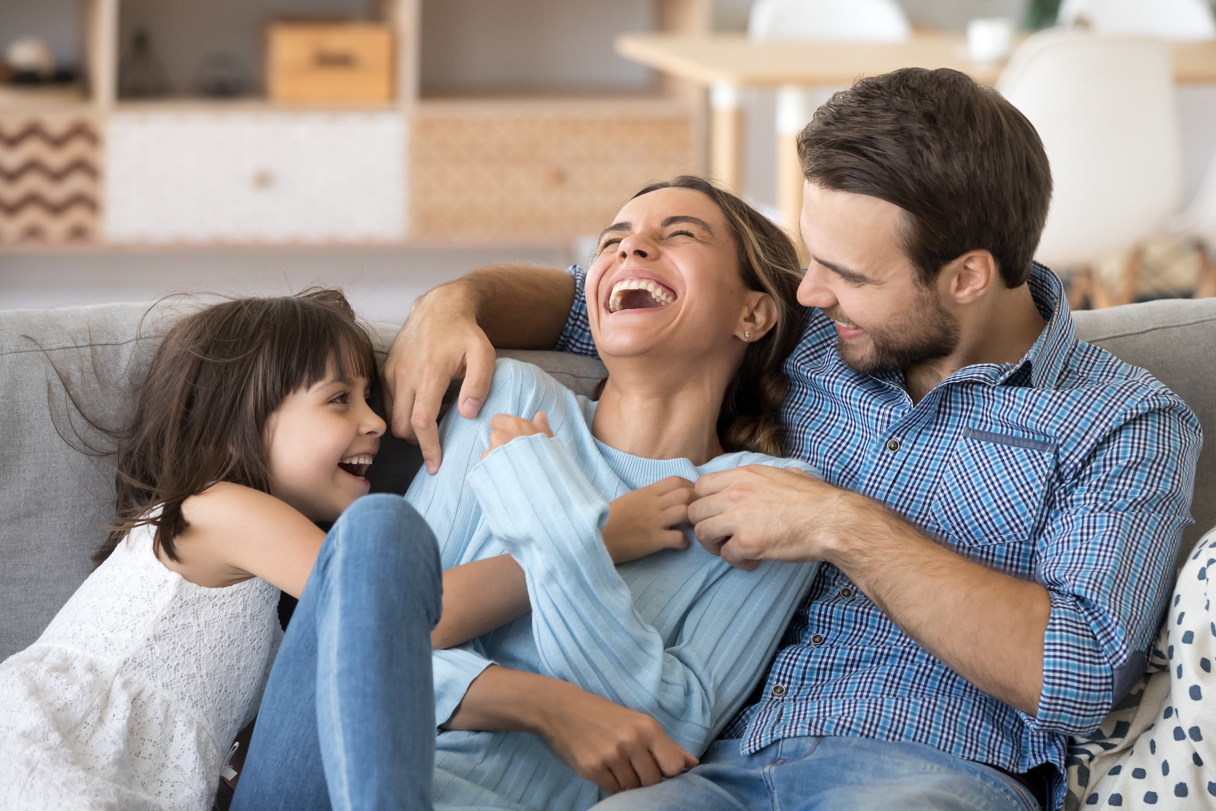 Happy Family In Living Room On Couch